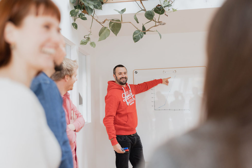 Coach erklärt agile Metriken und Schätzwerte an einem Whiteboard