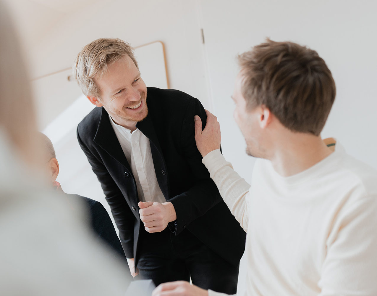 Chef spricht mit seinem Mitarbeiter und lacht